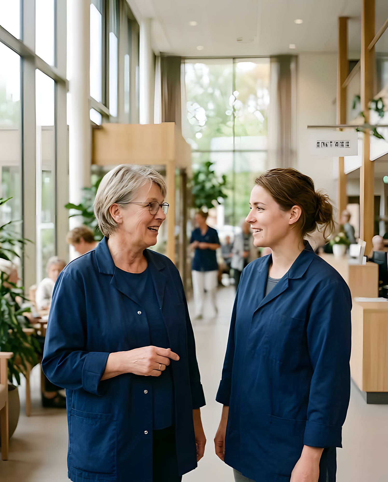 Twee zorgmedewerkers in gesprek op de afdeling